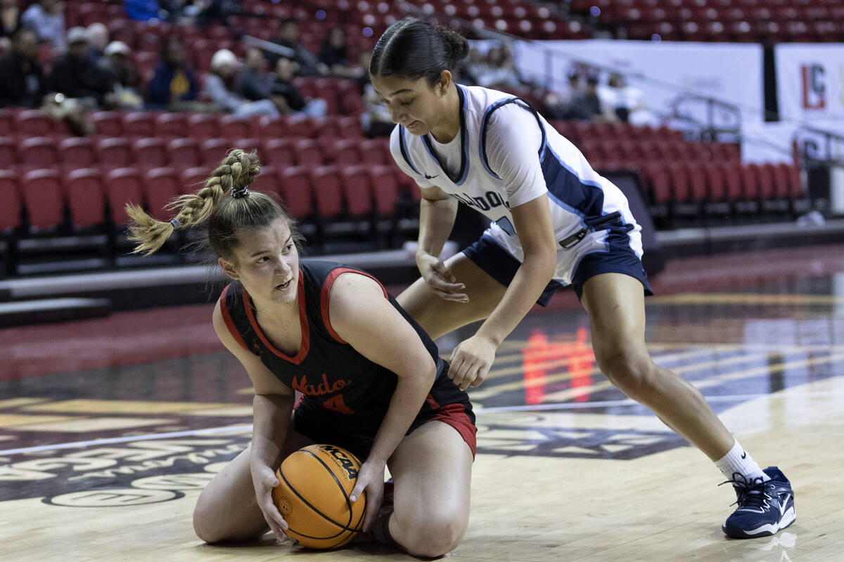 Coronado’s Savannah Lopez, left, wrestles the ball from the court to pass while Centenni ...