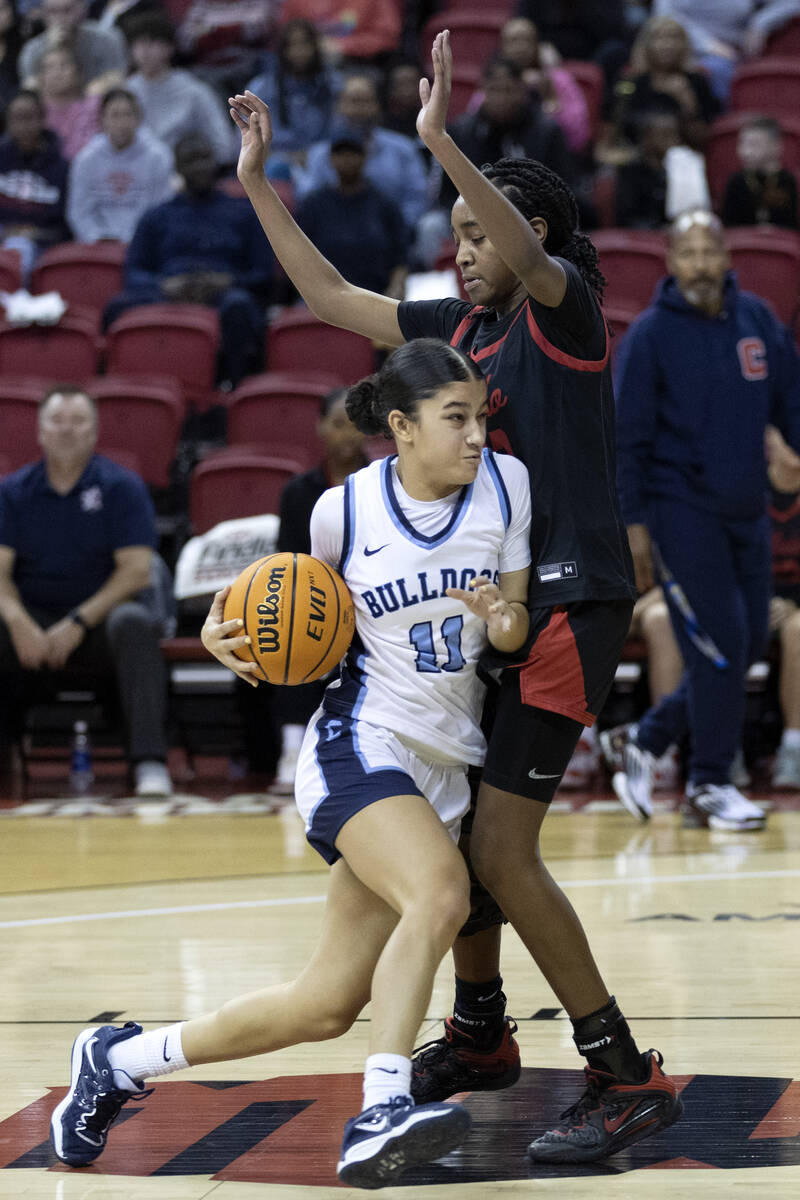 Centennial’s Danae Powell (11) drives toward the hoop past Coronado’s Jaila Child ...