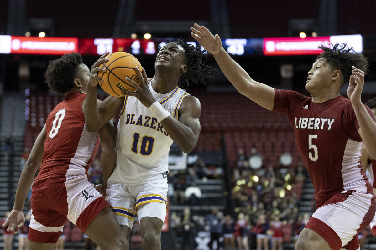 Durango’s Tylen Riley (10) shoots against Liberty’s Tyus Thomas (0) and Andre Por ...