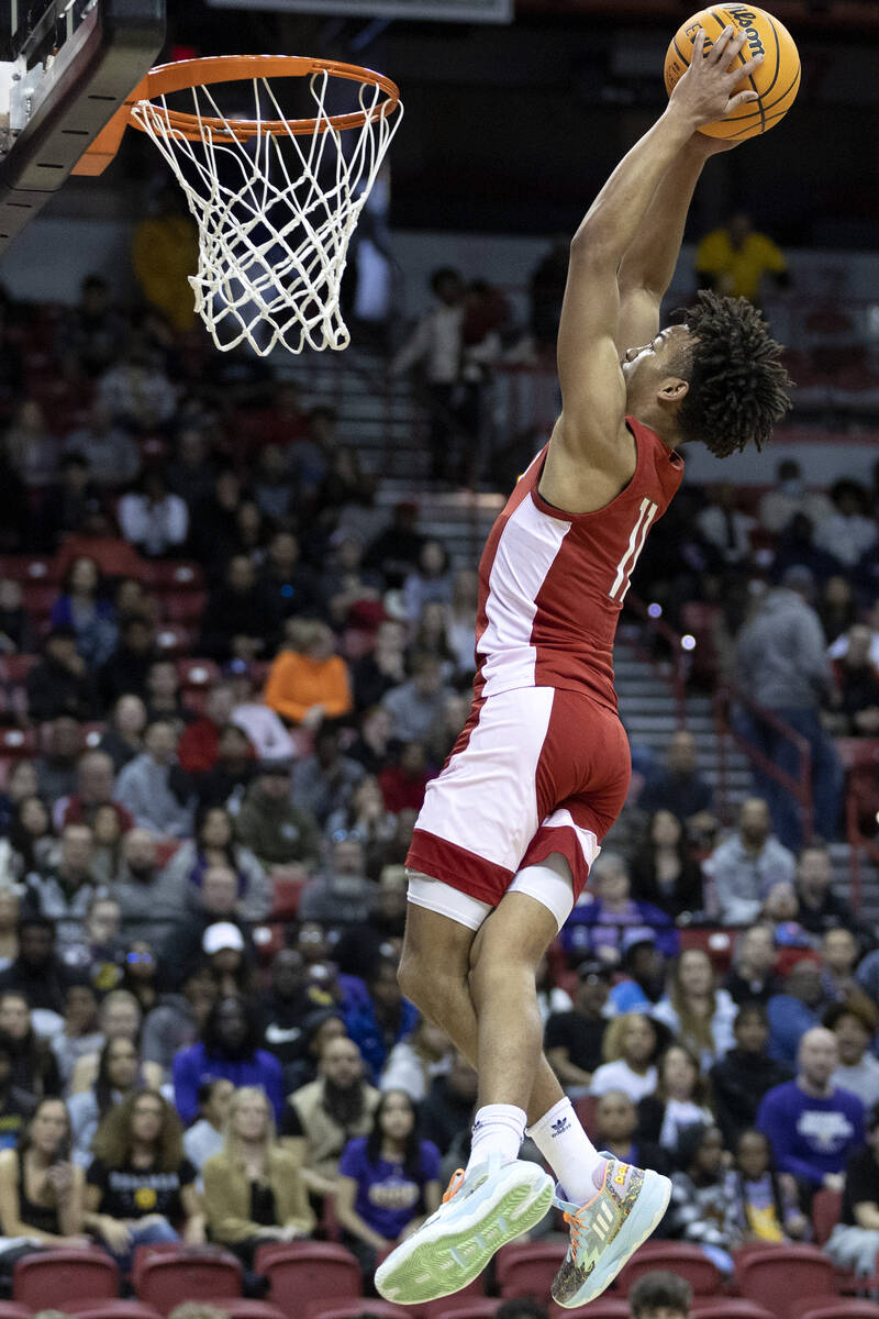Liberty’s Dedan Thomas (11) jumps to dunk during the first half of a Class 5A boys high ...