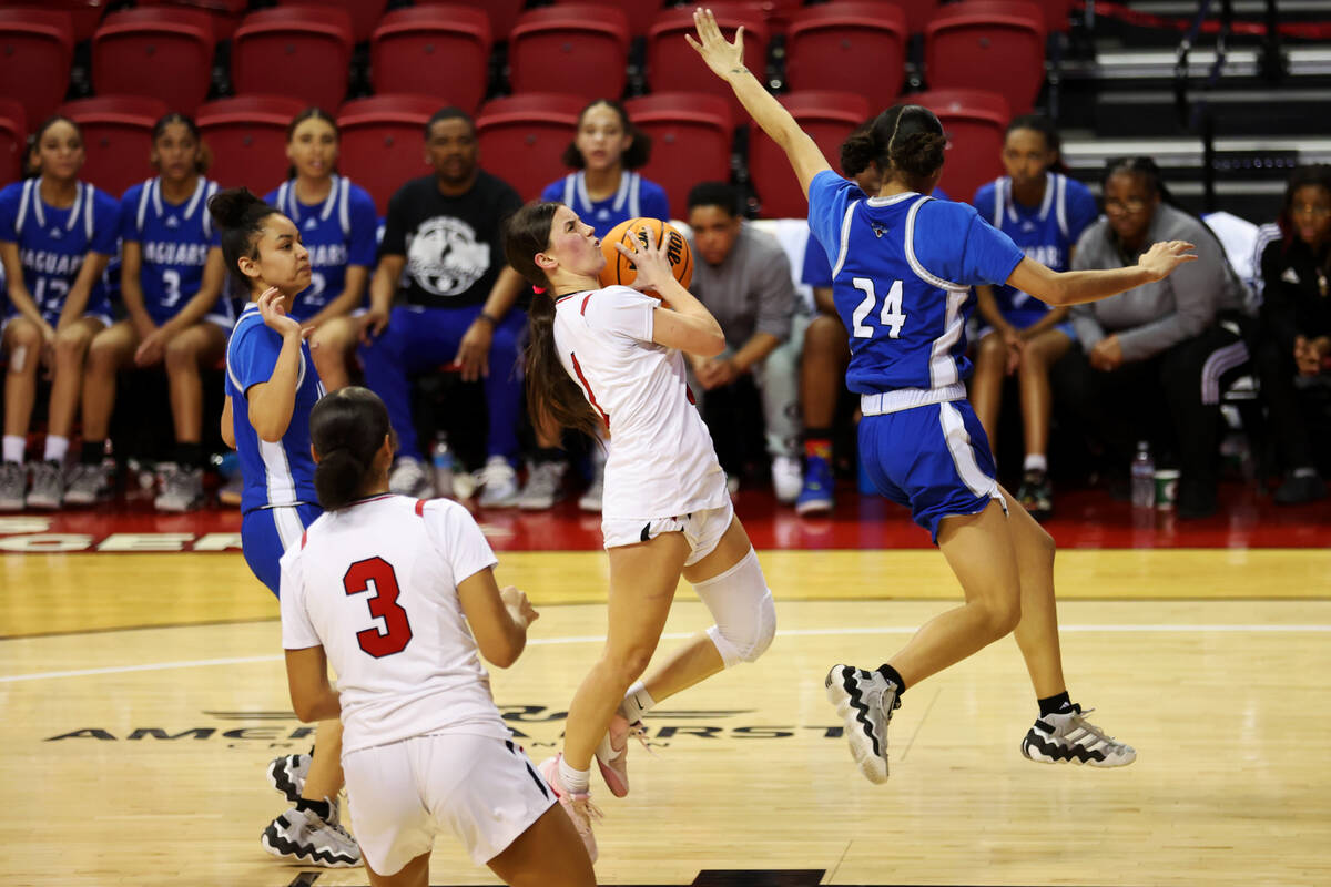 Las Vegas' Layla Faught (1) leaps for a shot under pressure from Desert Pines' Destiny Sao Mart ...