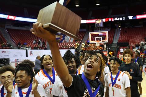 Mojave's Jameer McNeal (5) holds up the championship trophy after defeating Silverado during th ...