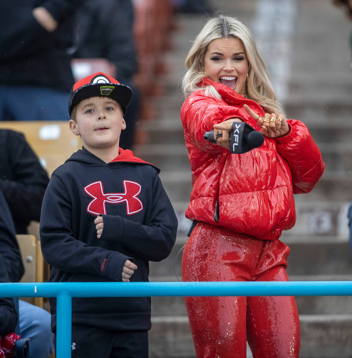 XFL host Jenn Stehlin, right, dances with a young fan during the first half of an XFL football ...