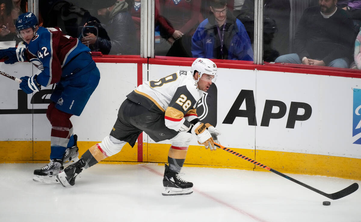 Vegas Golden Knights left wing William Carrier, right, collects the puck and skates away from C ...