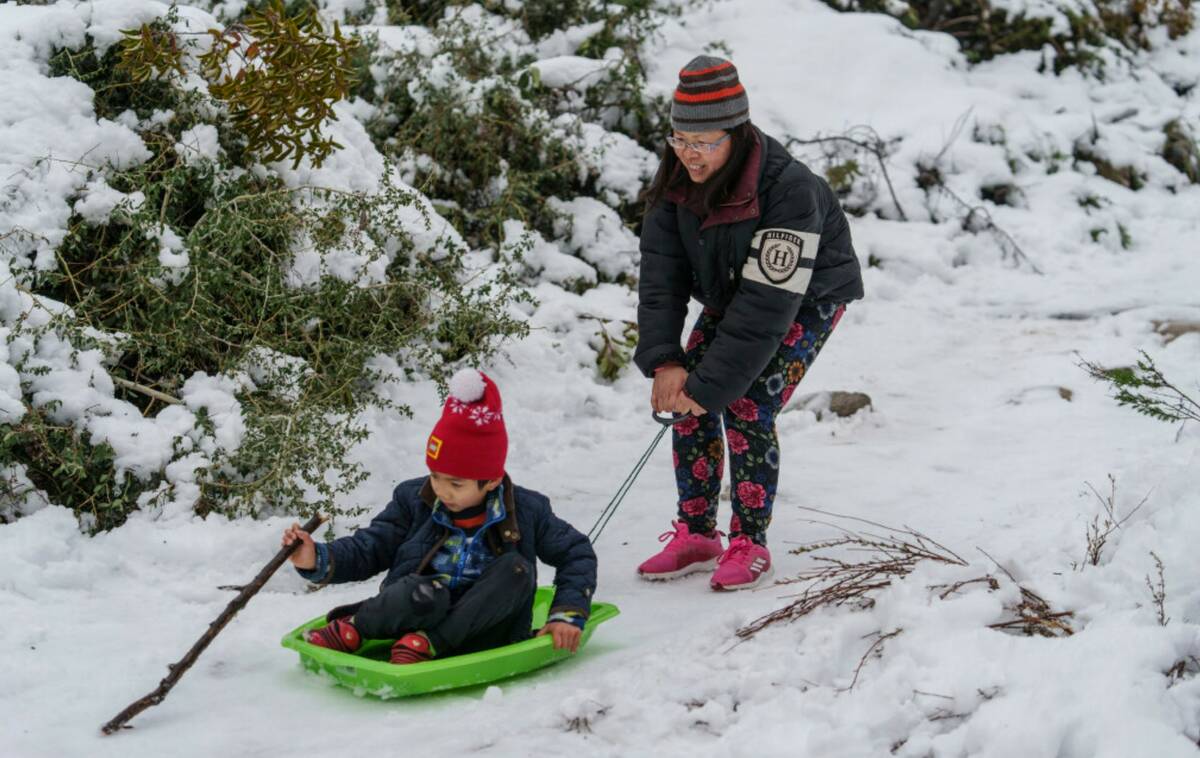 Aaron Lee, 7, and his mother play in the snow at the Deukmejian Wilderness Park, a rugged 709-a ...