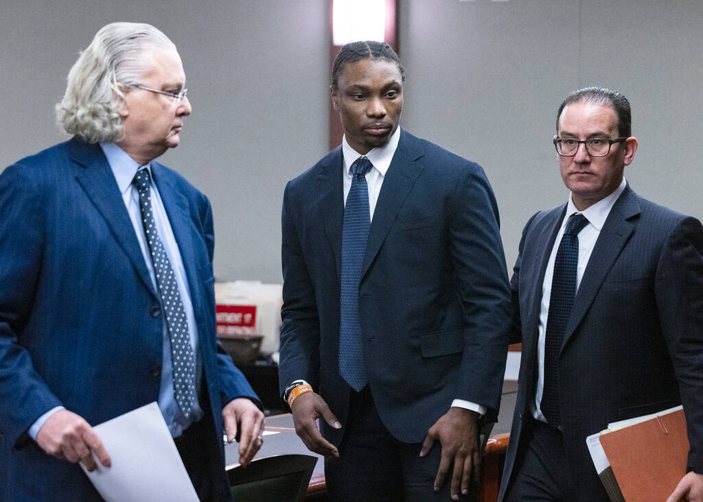 Ex-Raiders wide receiver Henry Ruggs, center, leaves the courtroom with his attorneys David Che ...