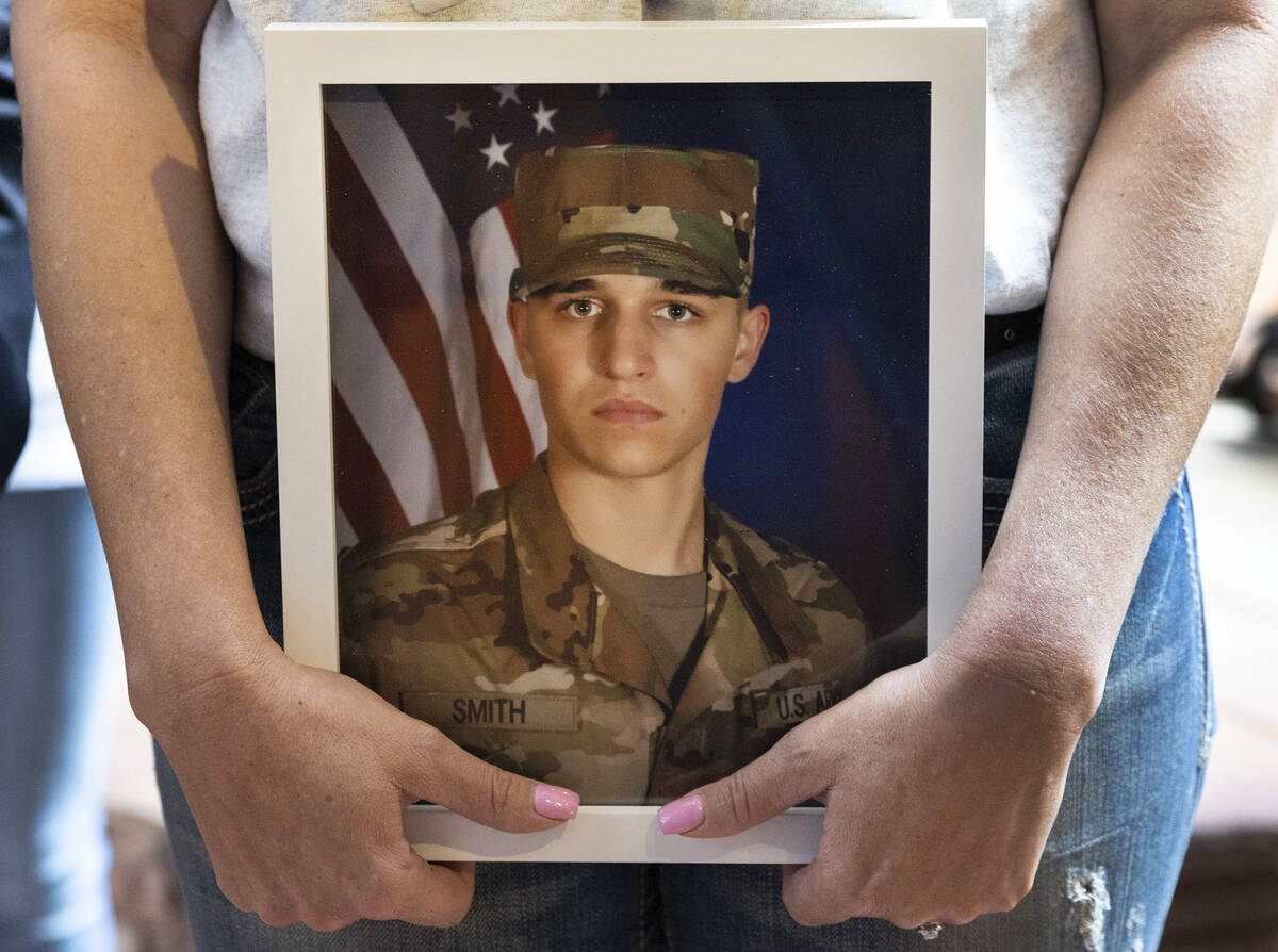 Kelli Norton, holds a photograph of her son Bailey Smith, a U.S. Army veteran, as she addresses ...