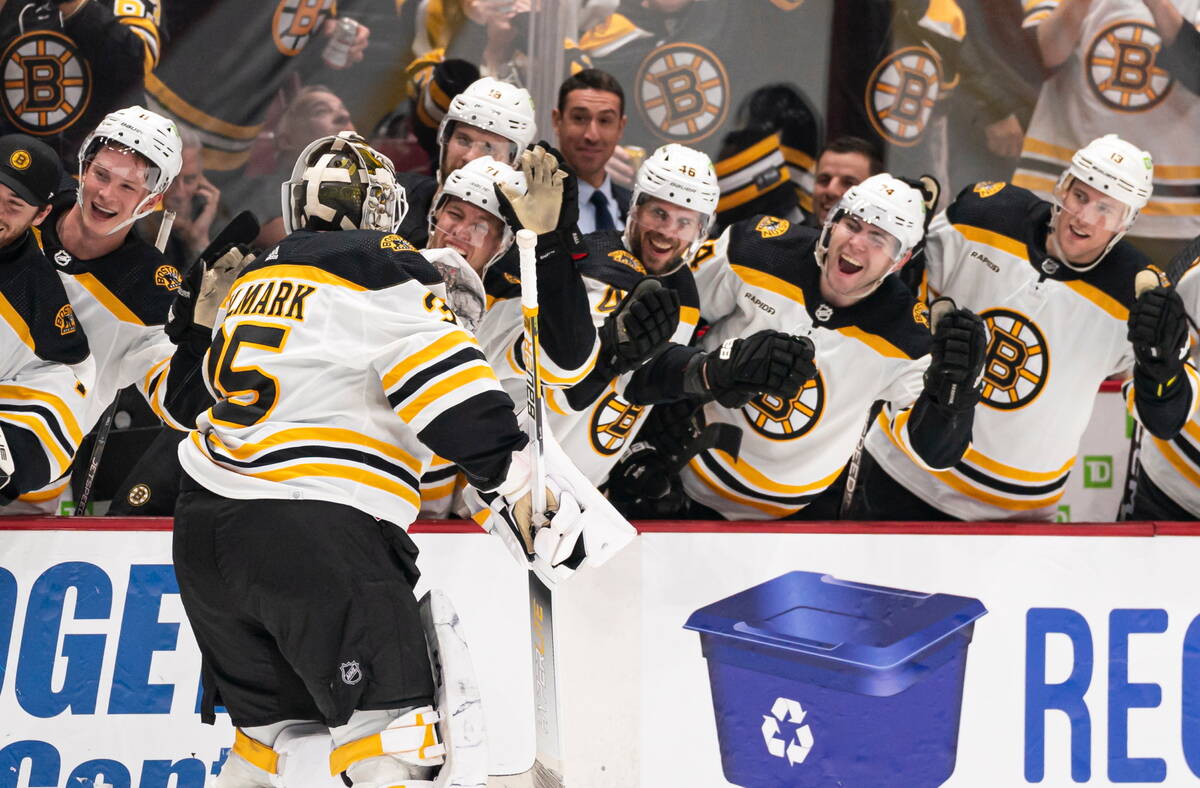 Boston Bruins goalie Linus Ullmark, left, celebrates his empty-net goal against the Vancouver C ...