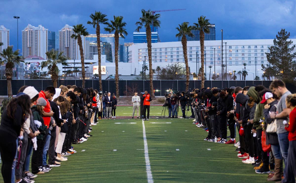 UNLV cornerbacks coach Akeem Davis leads a prayer as people bow their heads while standing on t ...