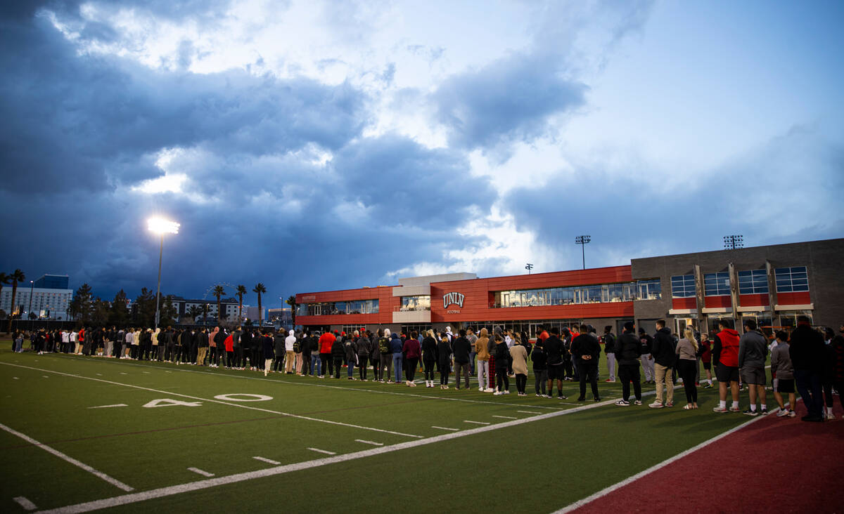 People gather on the 47-yard lines on the field at Rebel Park at the Fertitta Football Complex ...