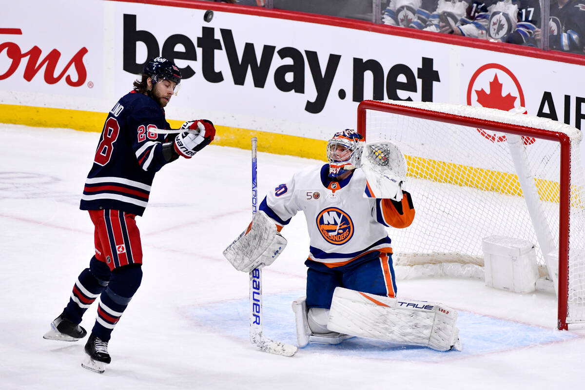 New York Islanders goaltender Semyon Varlamov (40) and Winnipeg Jets Kevin Stenlund (28) watch ...