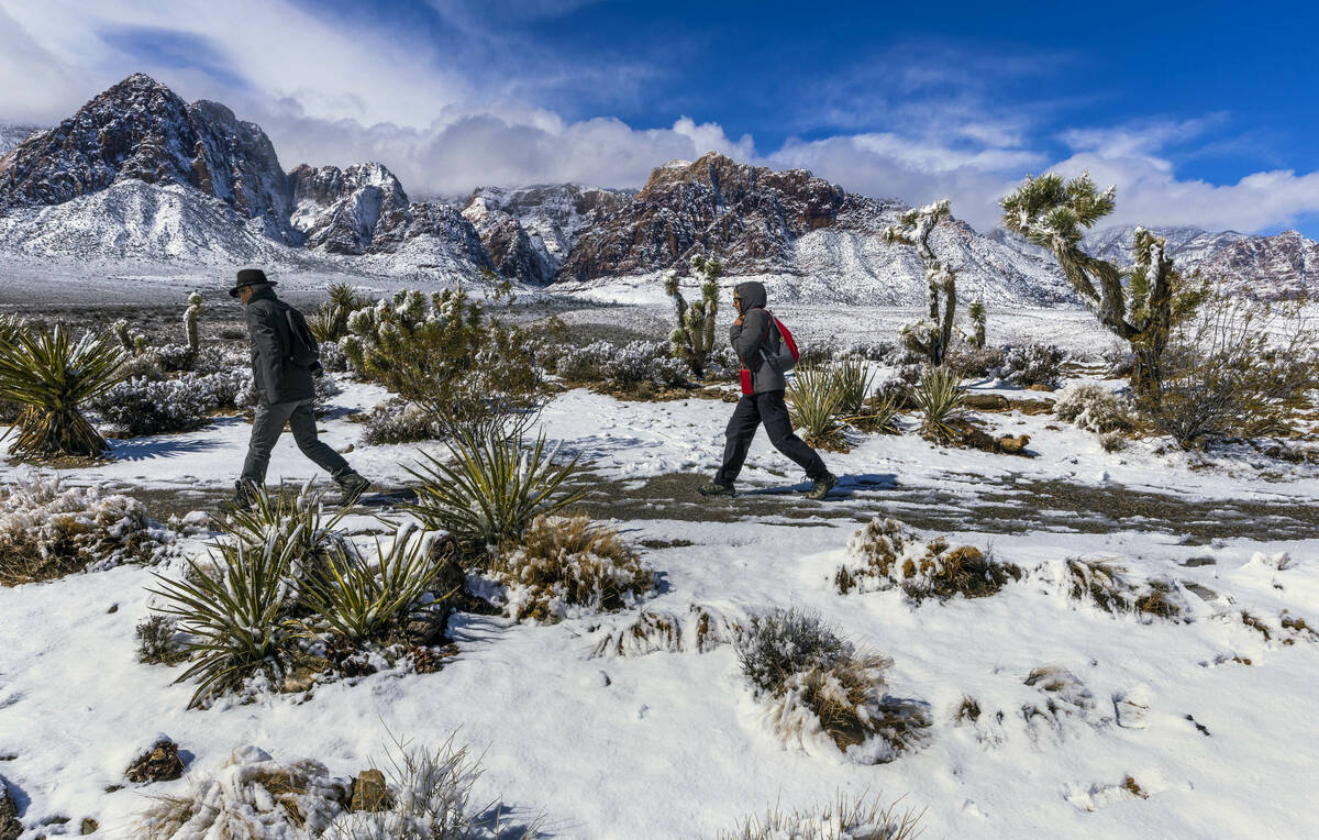 Visitors Andreas and Heidi Dornauf of Germany make their way down from a viewpoint ridge overlo ...