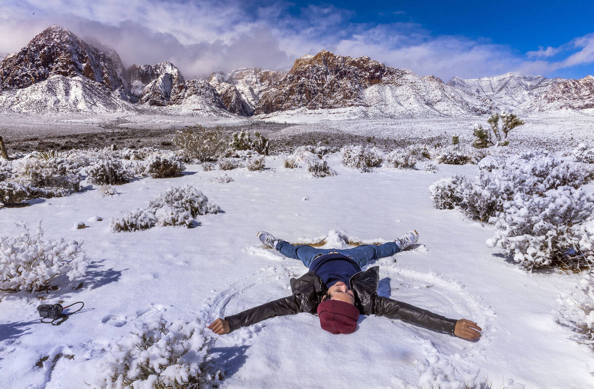 Visitor Tommy Liu from Taiwan makes a snow angel from a viewpoint ridge overlooking the Red Roc ...