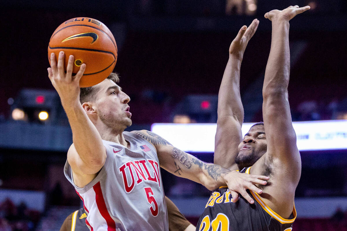 UNLV guard Jordan McCabe (5) elevates over Wyoming guard Ethan Anderson (20) for a score during ...