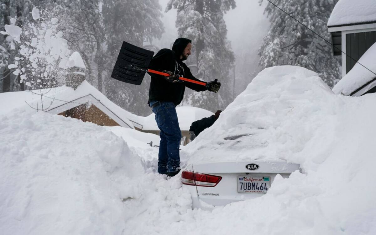 Kenny Rybak, 31, shovels snow around his car in Running Springs, Calif., Tuesday, Feb. 28, 2023 ...