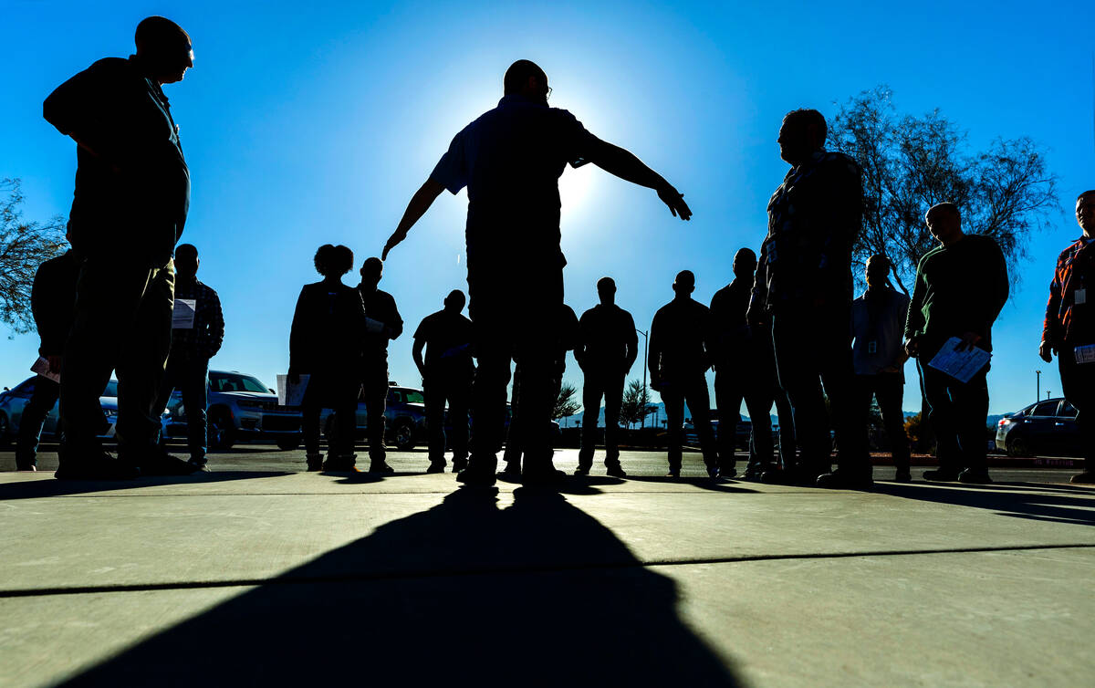 Metropolitan Police Department officer Mike Thiele, center, and his brother, Rob, left, review ...