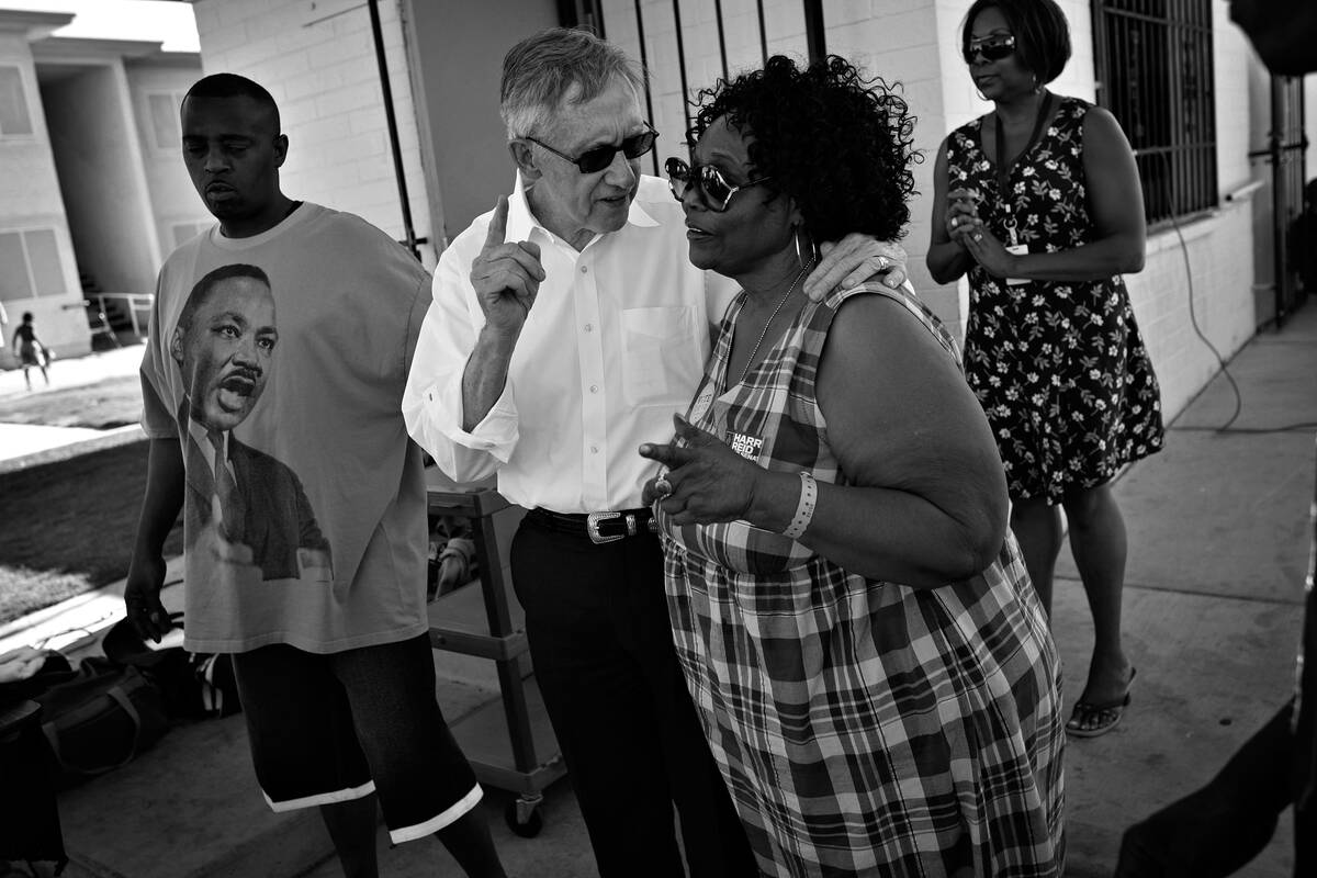 Sen. Harry Reid, in white shirt, speaks with Ruby Duncan while campaigning at a block party in ...
