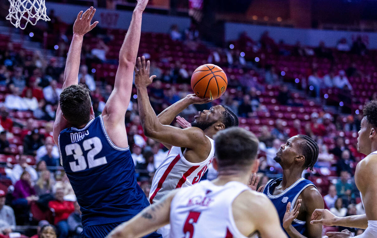 UNLV guard EJ Harkless (55) sets up for a shot past Utah State center Trevin Dorius (32) during ...