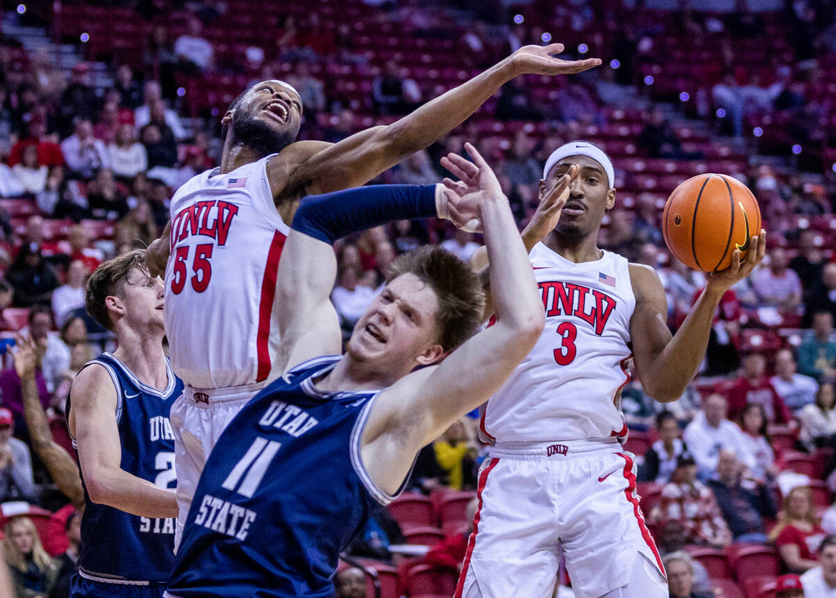 UNLV guard Shane Nowell (3) and guard EJ Harkless (55) secure a rebound from Utah State guard M ...