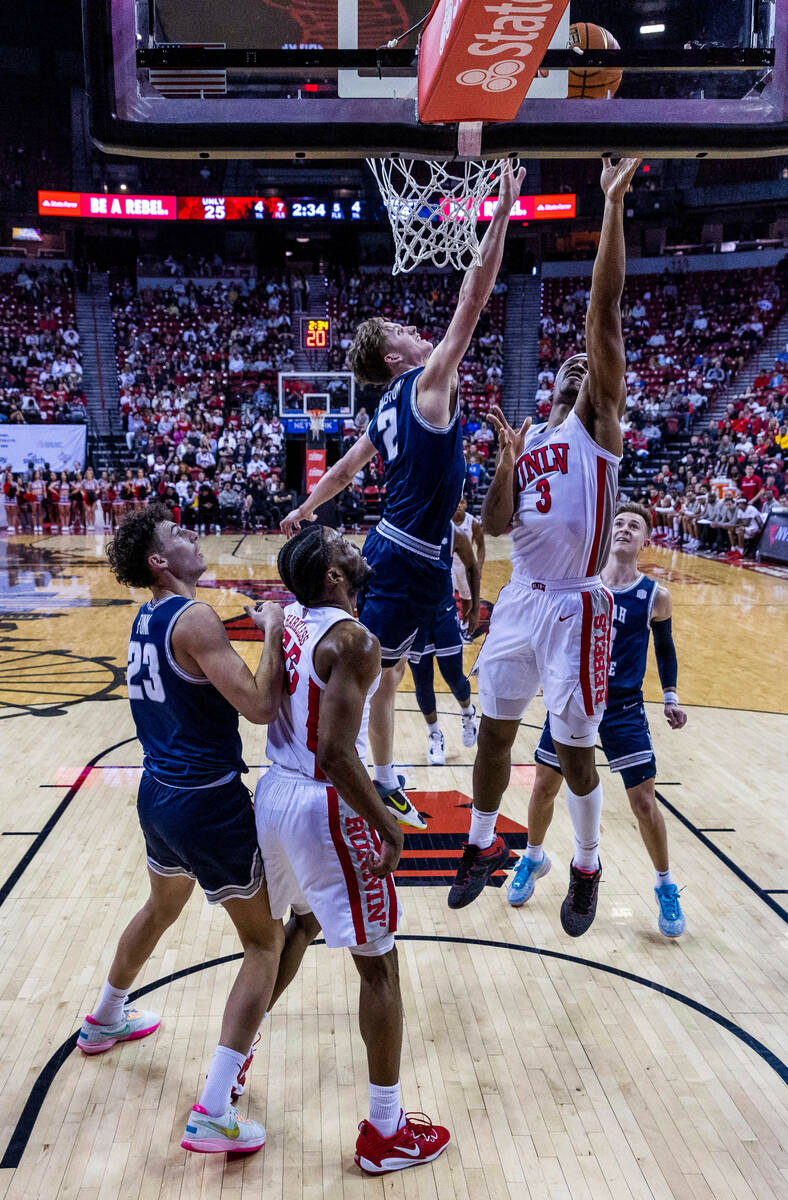 UNLV guard Shane Nowell (3) gets off a shot past Utah State guard Sean Bairstow (2) during the ...