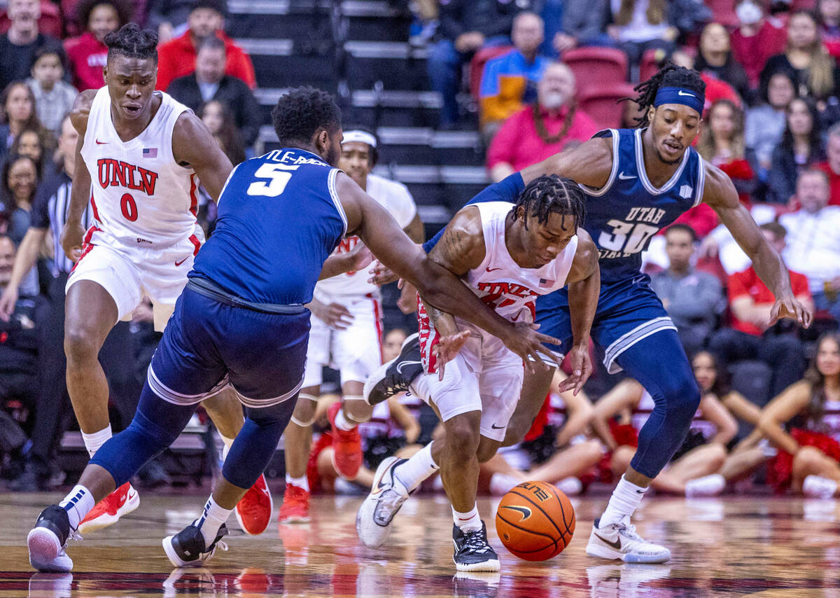 UNLV guard Jackie Johnson III (24) is fouled while chasing a loose ball by Utah State guard RJ ...