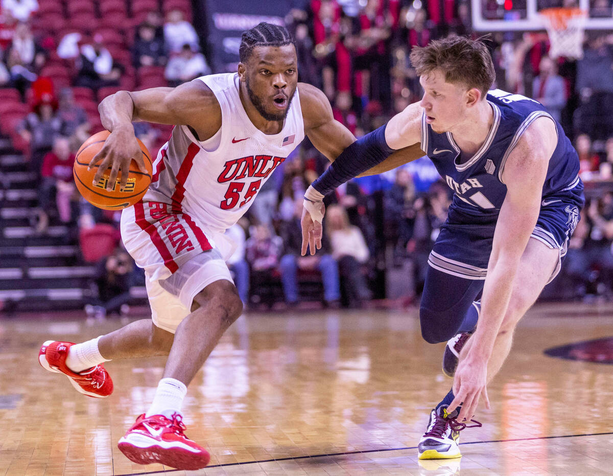 UNLV guard EJ Harkless (55) puts a move on Utah State guard Max Shulga (11) while driving to th ...