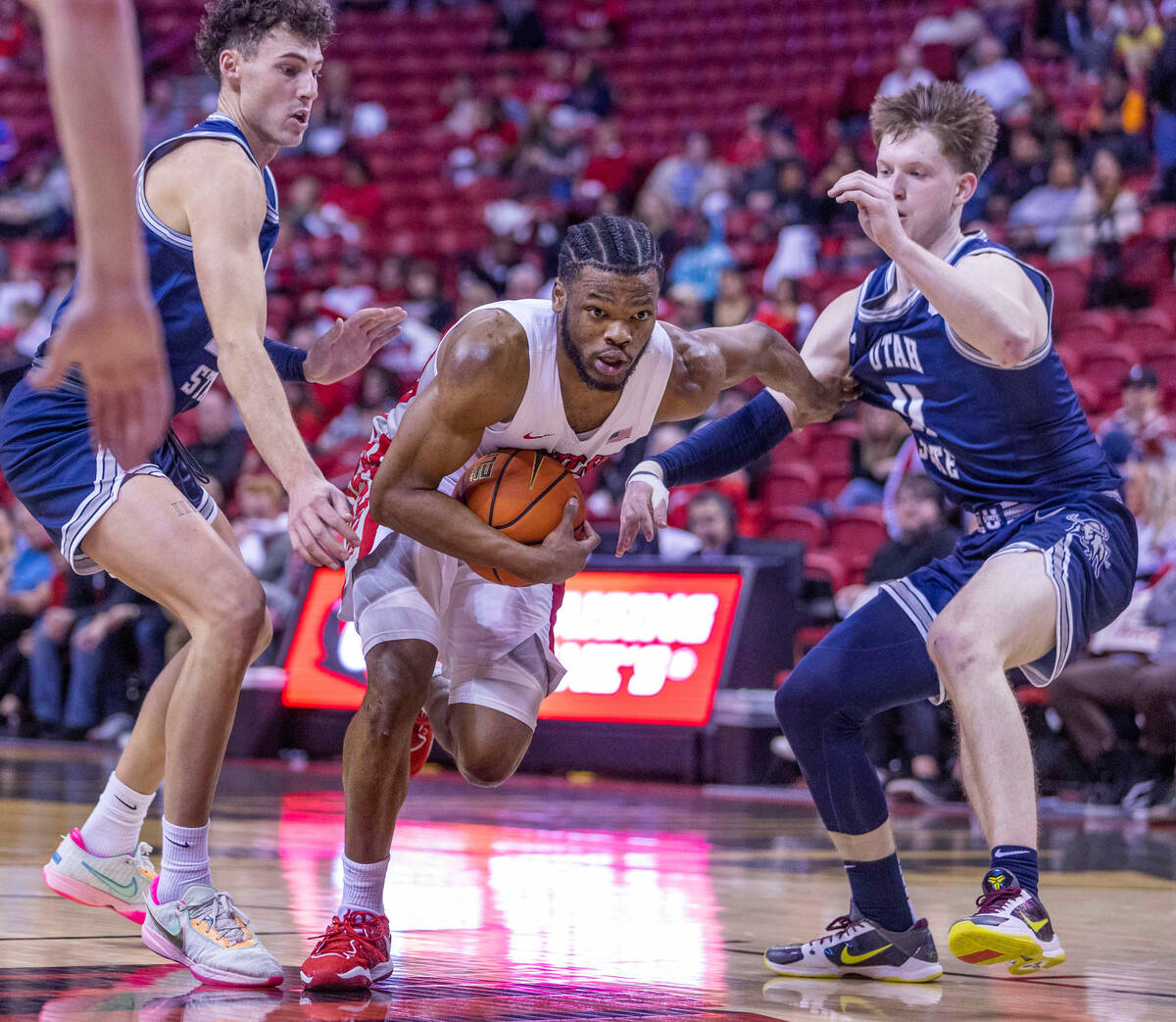 UNLV guard EJ Harkless (55) fights through the defense of Utah State forward Taylor Funk (23) a ...