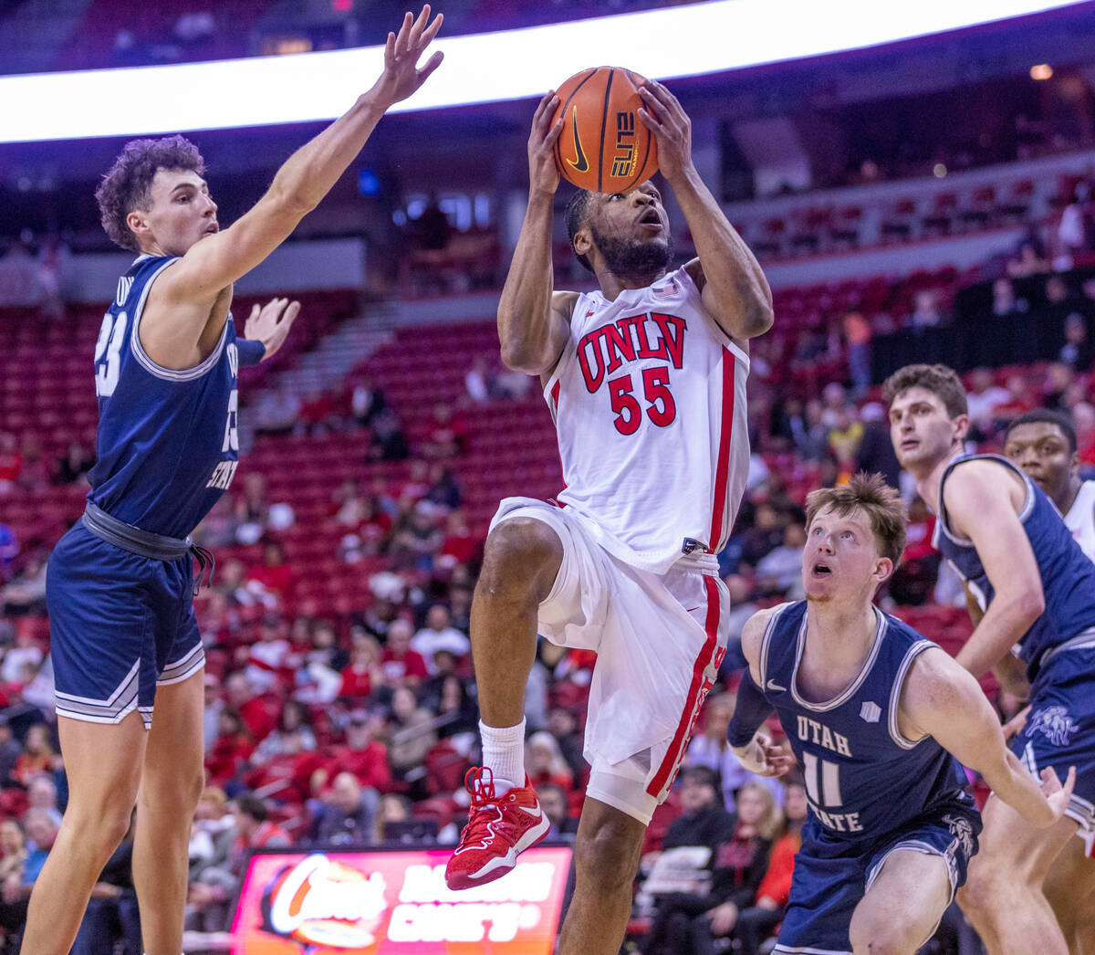 UNLV guard EJ Harkless (55) elevates for a shot past the defense of Utah State forward Taylor F ...