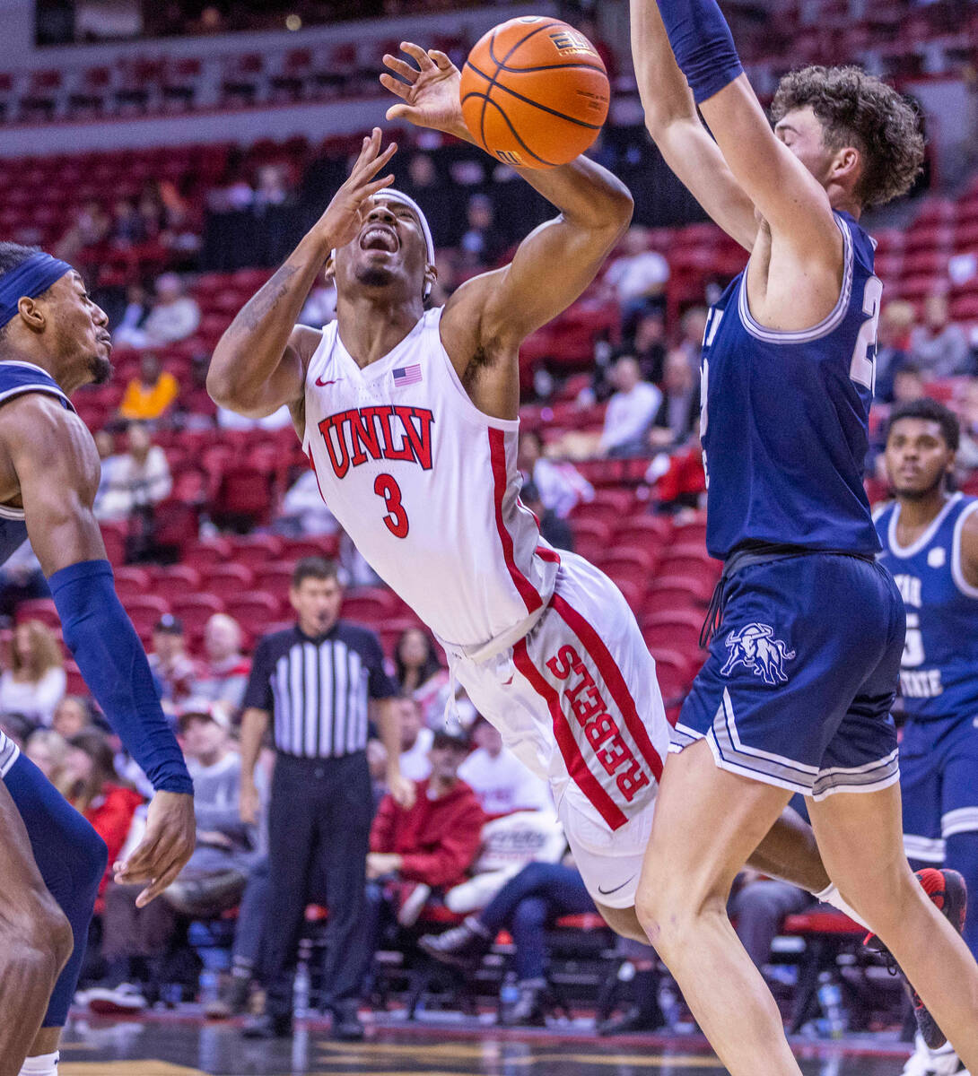 UNLV guard Shane Nowell (3) takes a hard foul in the lane from Utah State forward Taylor Funk ( ...