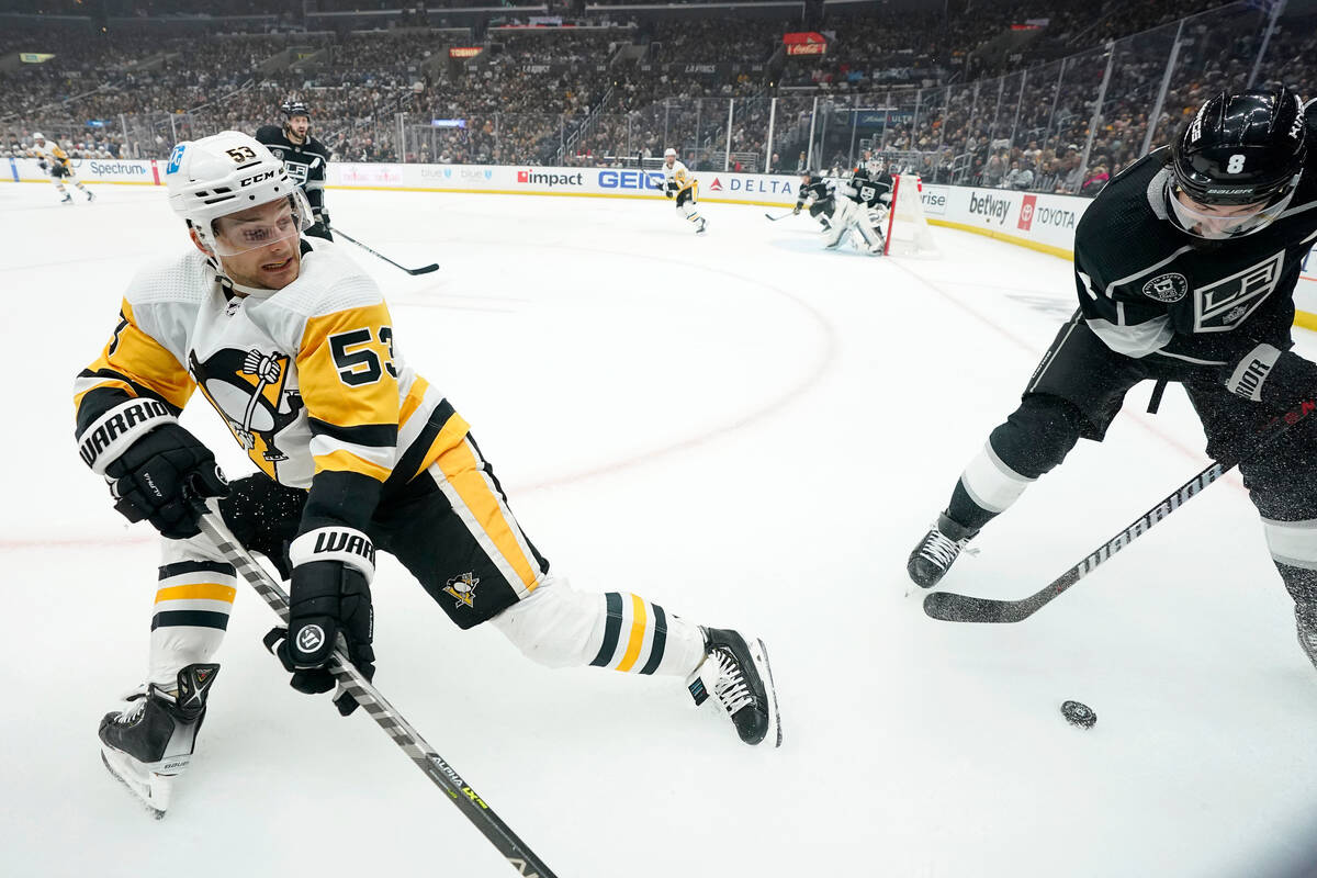 Pittsburgh Penguins center Teddy Blueger, left, falls as he vies for the puck with Los Angeles ...