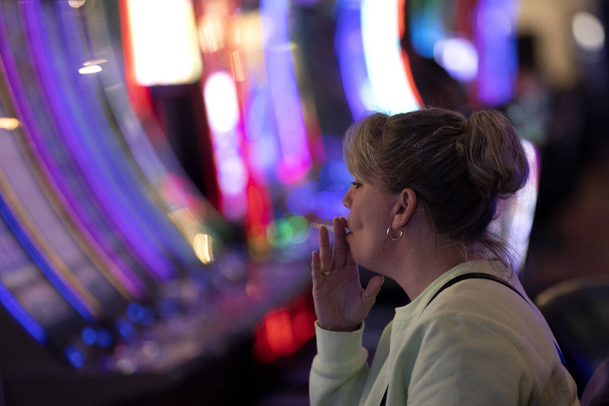 Linda, who declined to give her last name, smokes a cigarette while playing a game at The Plaza ...