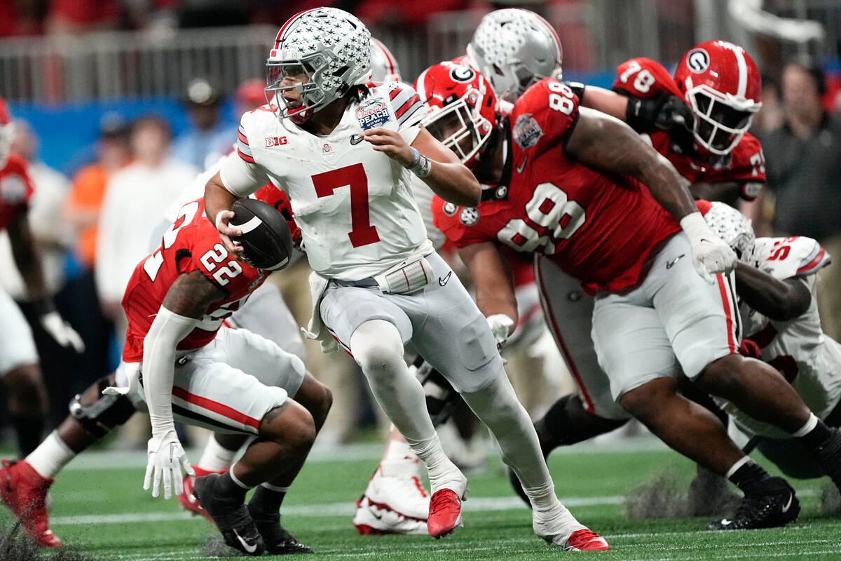 Ohio State quarterback C.J. Stroud (7) runs out of the pocket against Georgia during the second ...