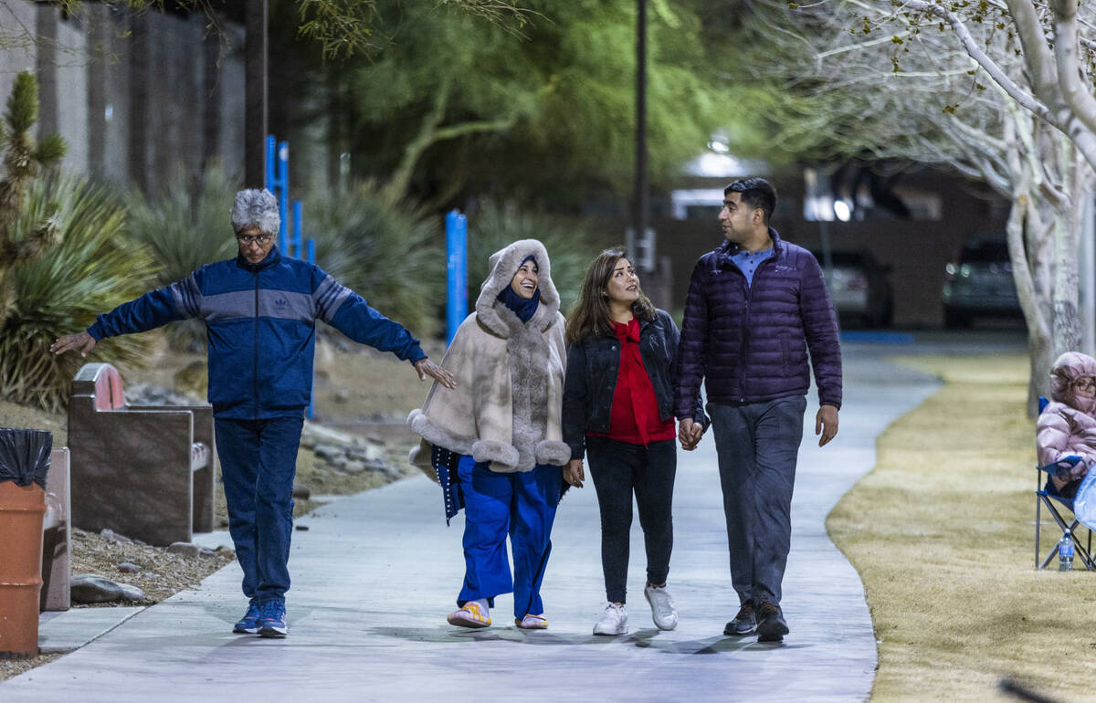 Abdul does some stretches while walking with wife Nazanin, daughter-in-law Shabana and son Moha ...