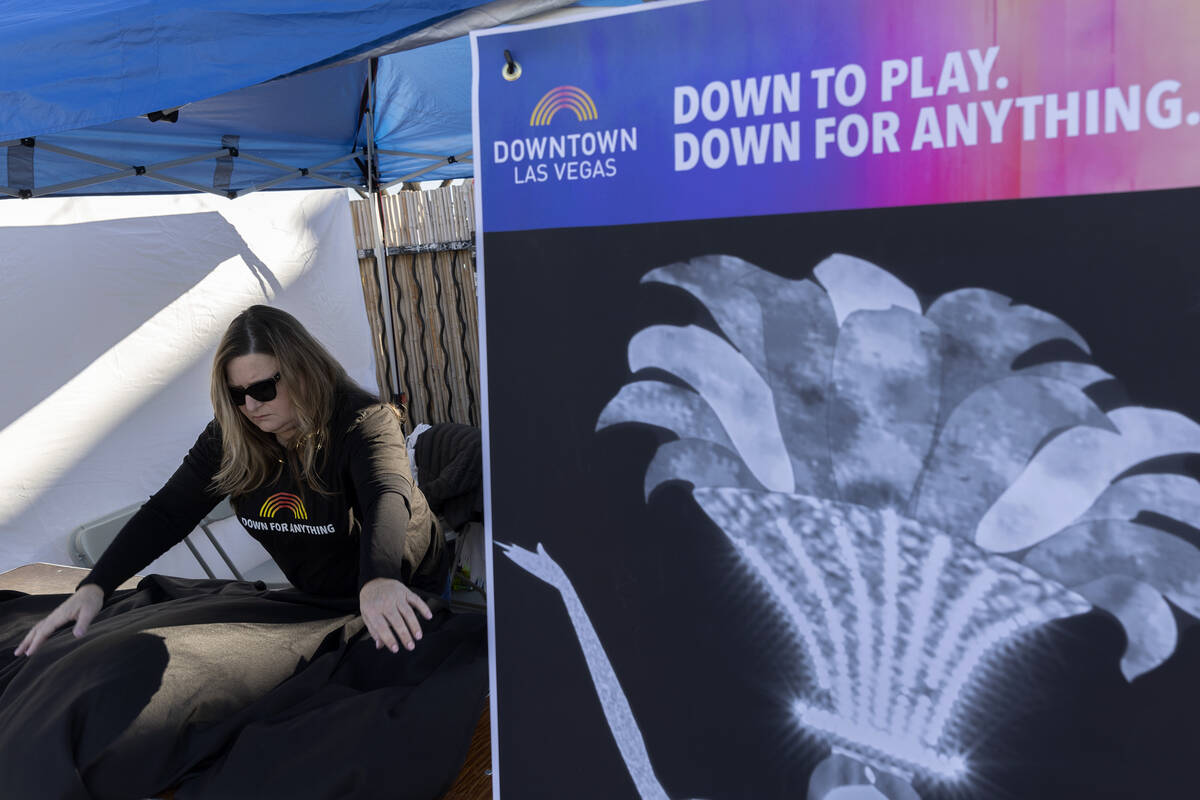 Carolyn Wheeler, executive director of the Downtown Vegas Alliance, helps to set up their booth ...