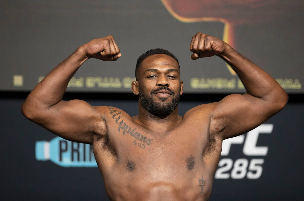 UFC heavyweight Jon Jones flexes on the scale for his weigh-in at the UFC Apex in Las Vegas on ...