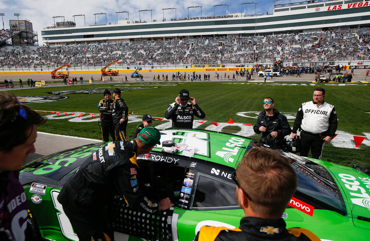 NASCAR Cup Series driver Kyle Busch, center, puts on his sunglasses before the start of the Pen ...