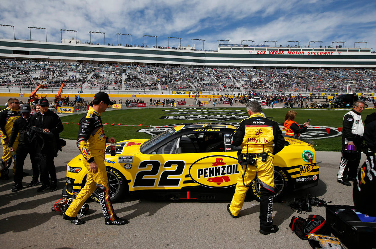 Driver Joey Logano, left, checks is car on pit road before the start of the Pennzoil 400 NASCAR ...