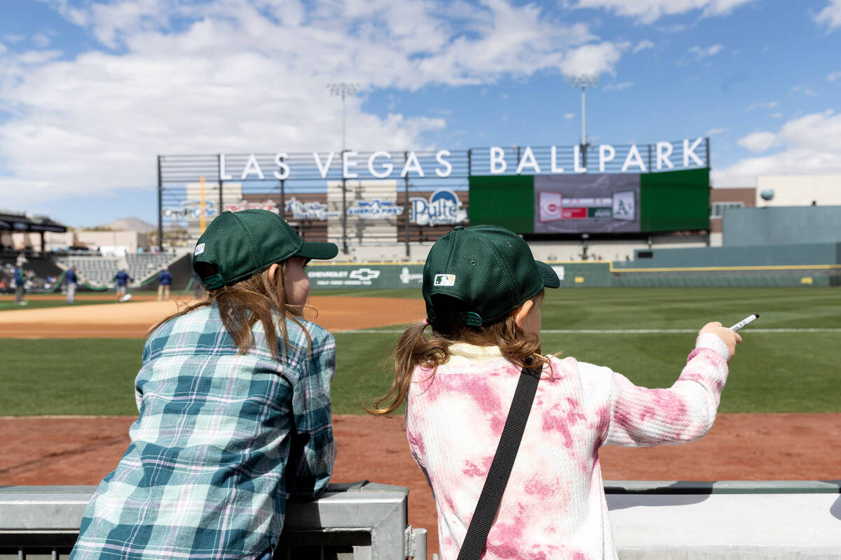Alexandra Ritz, 10, left, and Indie Erardy, 7, call to Oakland Athletics players to get basebal ...