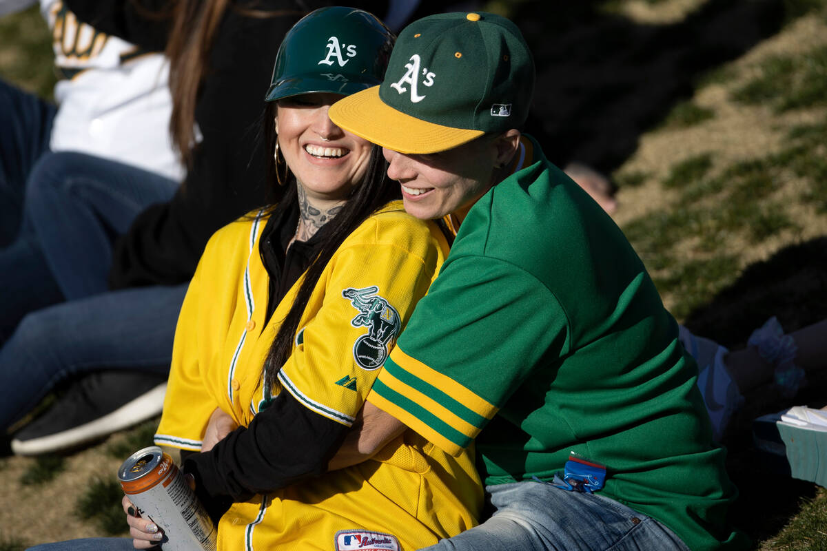 Oakland Athletics fans embrace in the outfield seating area during an MLB exhibition game again ...
