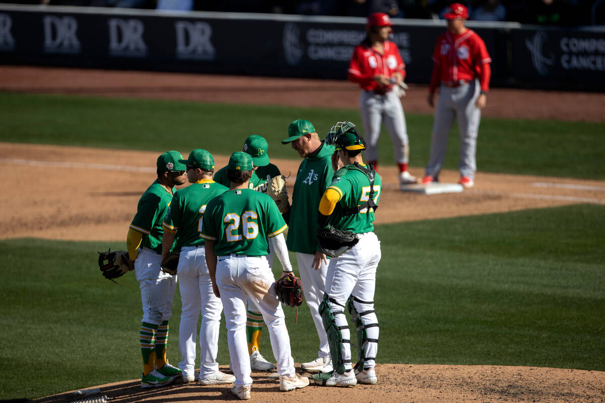 Oakland Athletics pitching coach Scott Emerson huddles with the team during an MLB exhibition g ...