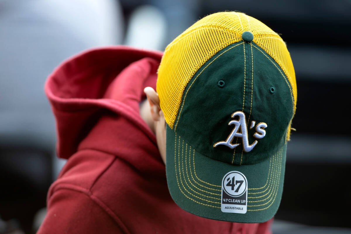 An Oakland Athletics wears a team hat during an MLB exhibition game against the Cincinnati Reds ...