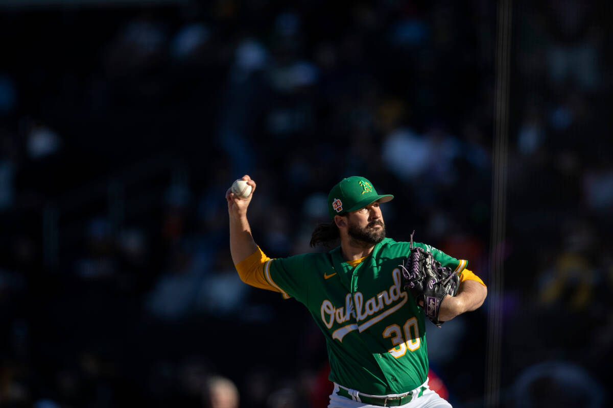 against the Oakland Athletics pitcher Chad Smith throws to the Cincinnati Reds during an MLB ex ...