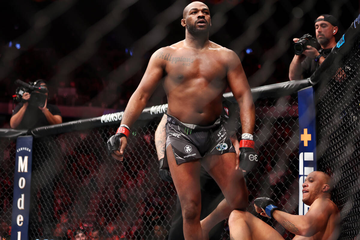 Jon Jones, left, walks away after submitting Ciryl Gane in the first round of a heavyweight tit ...