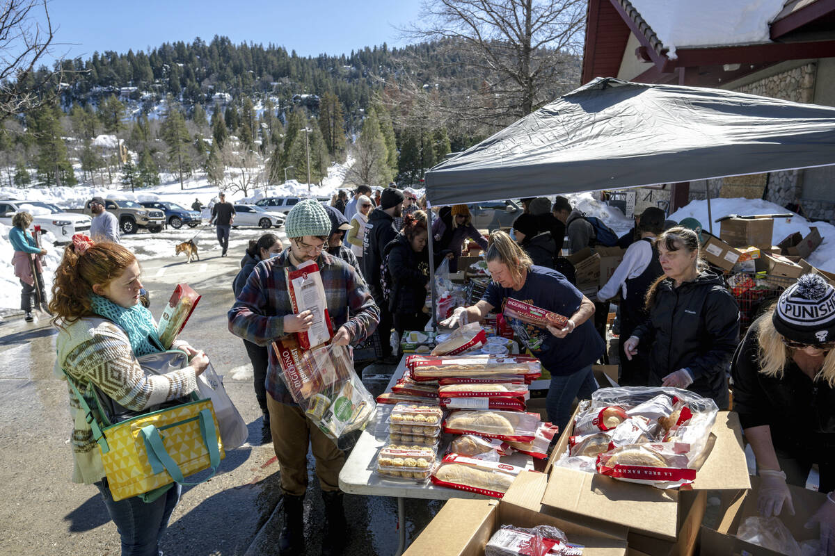 Crestline residents receive free food at a tent set up in front of the Goodwin & Son's Mark ...
