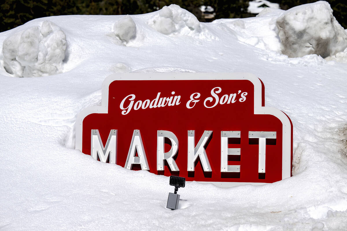 The Goodwin & Son's Market sign is buried in feet of snow in Crestline, Calif., Friday, Mar ...