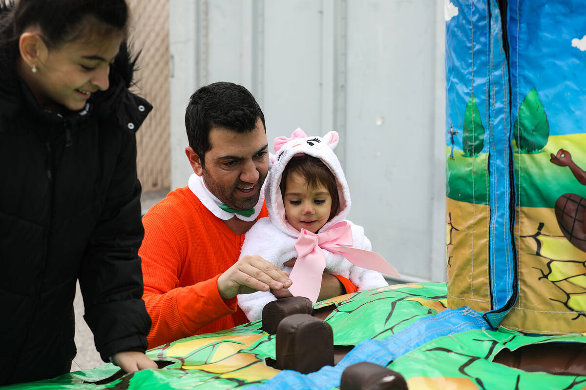 Rosen Lubaton, left, plays with his daughter Ariana Lubaton, 2, at a parade for the Jewish holi ...