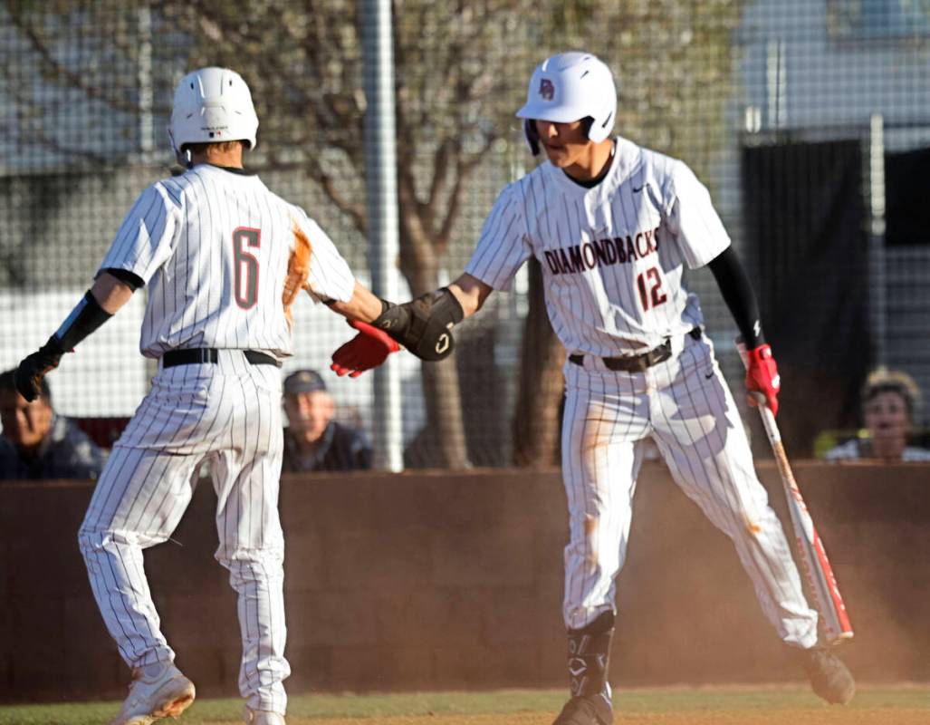 Desert Oasis’ Ryan Martin (6) gets a high-five from his teammate Seth Lyons (12) after ...