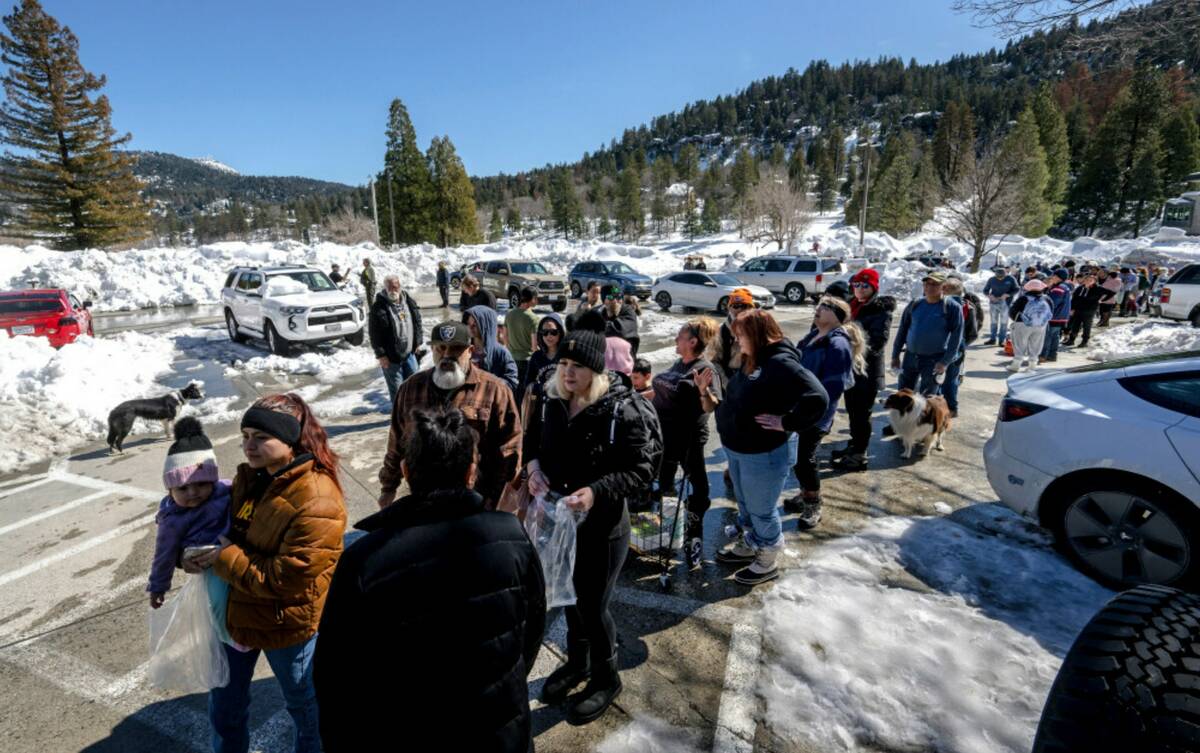 San Bernardino Mountain residents line up for a chance to get food at a tent in front of the Go ...