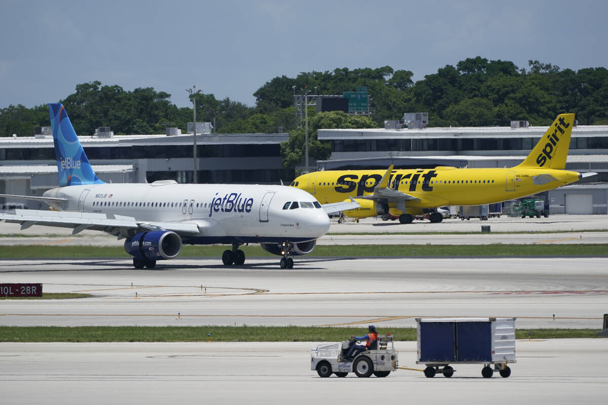 A JetBlue Airways Airbus A320, left, passes a Spirit Airlines Airbus A320 as it taxis on the ru ...