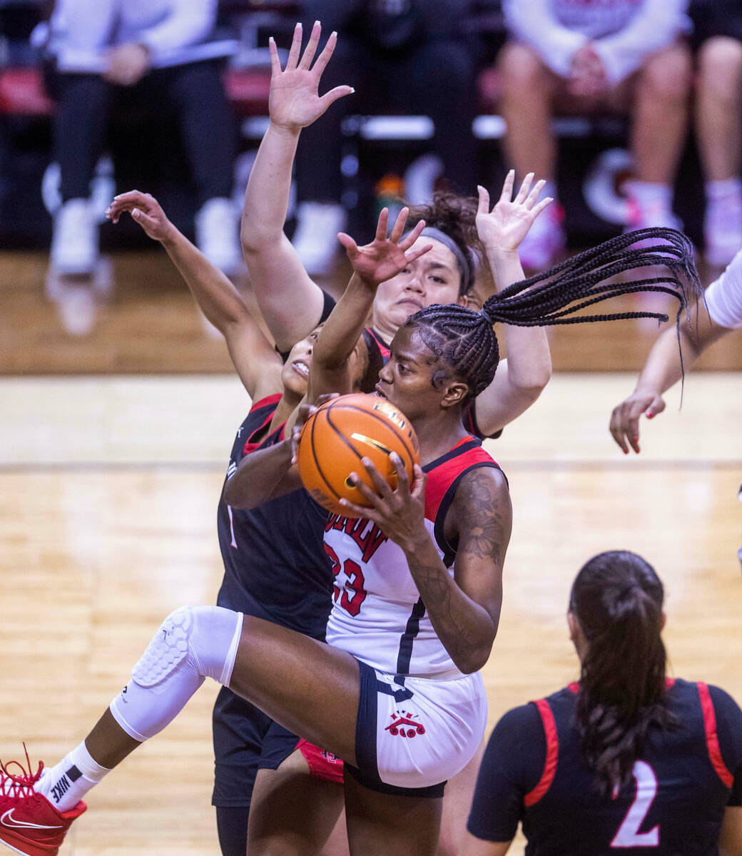 UNLV center Desi-Rae Young (23) battles to get a shot off over San Diego State guard Asia Aving ...